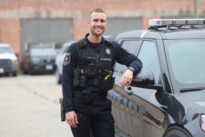 Morris Police Officer Ryan Ties stands by his squad car outside the police station on Tuesday, March 26, 2024.