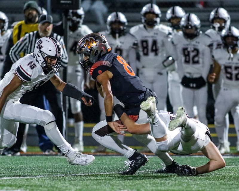 Minooka's Kameron Hopkins (8) is brought down behind the line of scrimage by Plainfield North's Kyle Darlington (32) during football game between Plainfield North at Minooka.   Oct 6, 2023.
