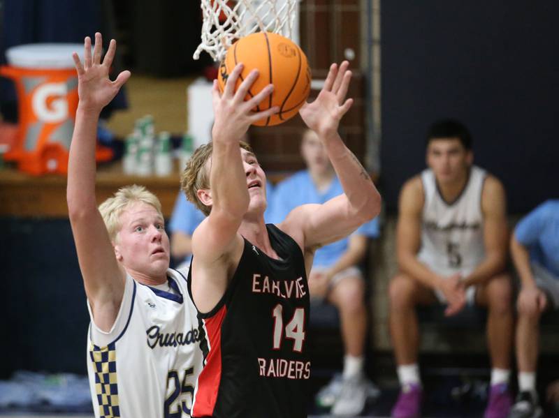 Earlville's Adam Waite drives to the hoop as Marquette's Luke McCullough defends on Friday, Jan. 3, 2025 in Bader Gym at Marquette High School.