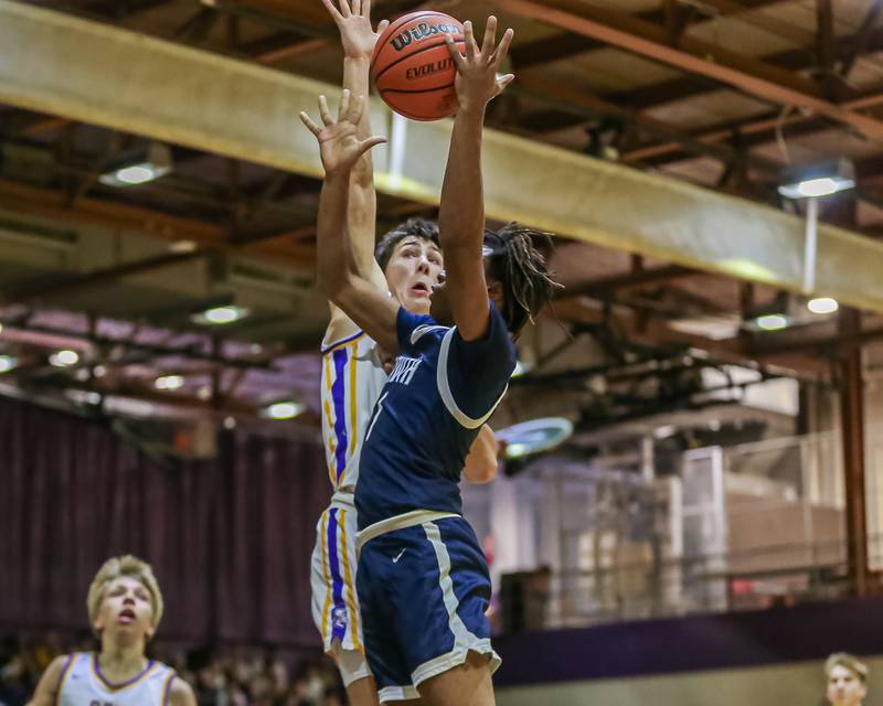 Downers Grove South's Keon Maggitt (1) attempts a lay up defended by Downers Grove North's Jack Stanton (21) during basketball game between Downers Grove South at Downers Grove North. Dec 16, 2023.
