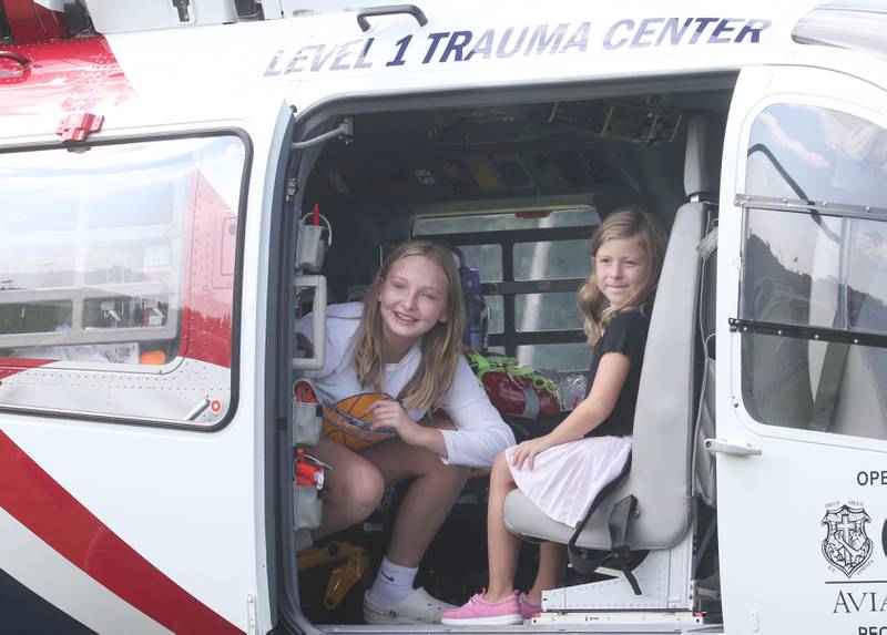 Shaylynn Keckler and Olivia Christmann of Oglesby, take a photo inside OSF Lifeflight helicopter during National Night Out on Tuesday, Aug. 5, 2025 in Oglesby. Oglebsy Police, Fire and EMS along with Utica Fire, Illinois State Police and OSF Lifeflight helicopter also attended. The event featured food, foam machine, bounce house, games and more. National Night Out is an annual community policing campaign held on the first Tuesday of August to create police-community partnerships and build safer neighborhoods