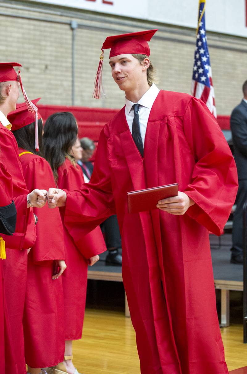 Ryan Nelson fist bumps a class officer Friday, May 27, 2022, after receiving his diploma.