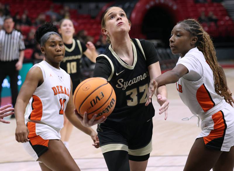 Sycamore's Quinn  Carrier goes to the basket between DeKalb's Johnna Patrick (left) and Me'She Eubanks Friday, Jan. 30, 2026, during their game in the FNBO Challenge in the Convocation Center at Northern Illinois University in DeKalb.