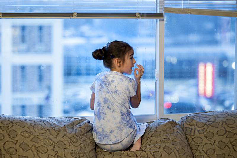 Nastya, 7, sits in the window of the apartment looking over an area of Dixon. Once the family made contact with a local group in Dixon, it took just a couple month to move the family over.