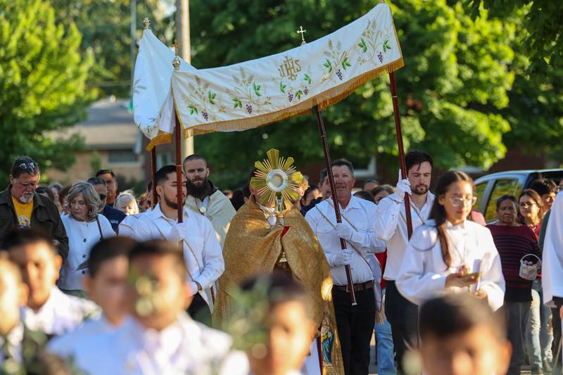 The Rev. Matthew Pratscher, pastor of St. John Paul II, carries the Eucharist in the monstrance as part of the National Eucharistic Pilgrimage procession around St. John Paul II Catholic Church on Sunday, May 18, 2025.