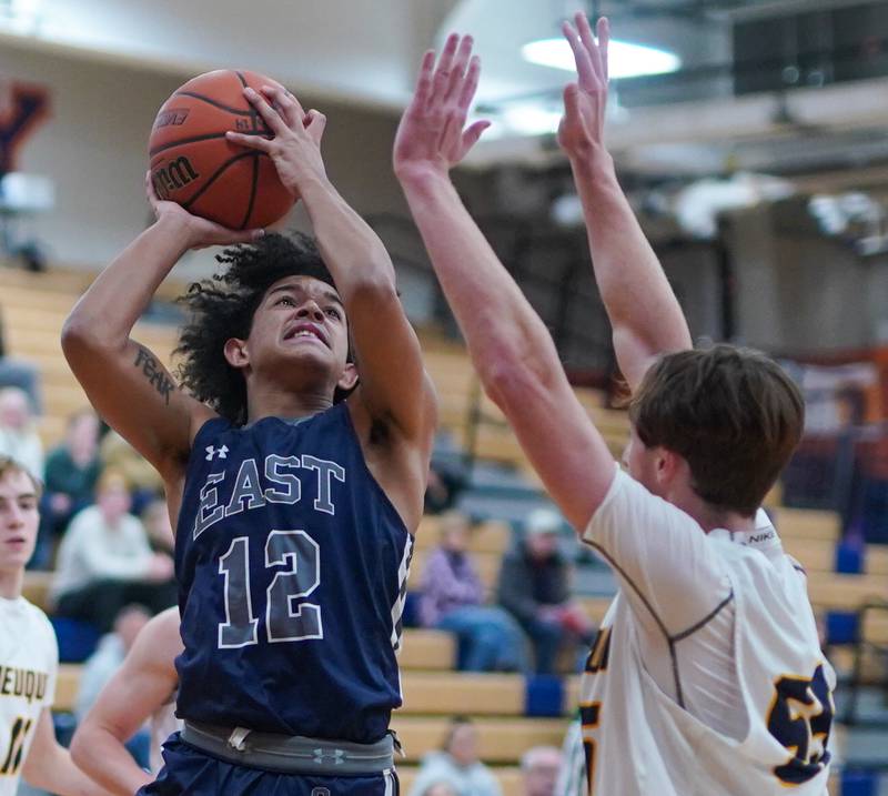 Oswego East's Drey Wisdom (12) shoots the ball in the post against Neuqua Valley during a hoops for healing basketball tournament game at Oswego High School on Friday, Nov 24, 2023.