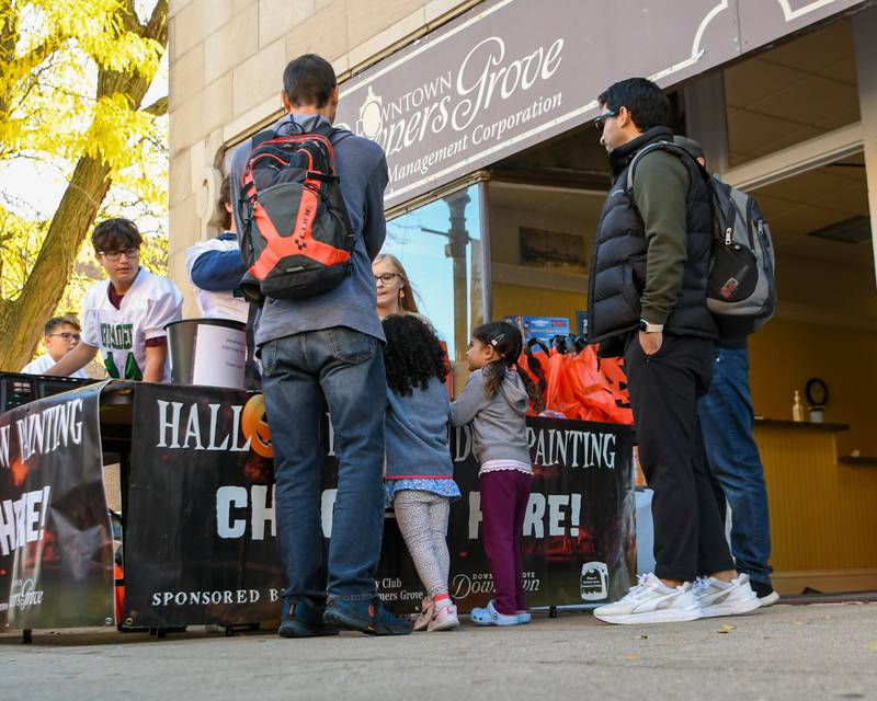 Participants get their supplies during the Halloween Window painting event held in Downtown Downers Grove on Saturday Oct. 21, 2023.