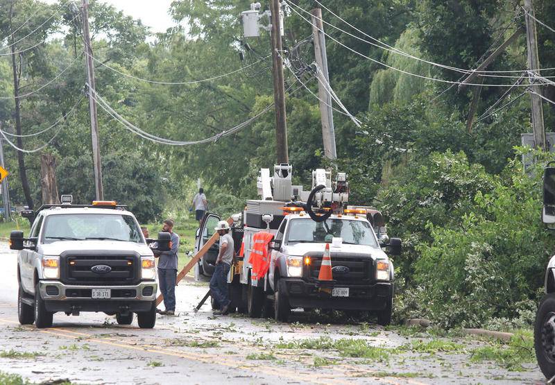 ComEd crews work on downed power lines on First Street in DeKalb Monday afternoon after a severe storm passed through the area. High winds, lightning and heavy rain caused damage consisting mainly of downed trees and power lines throughout DeKalb County.