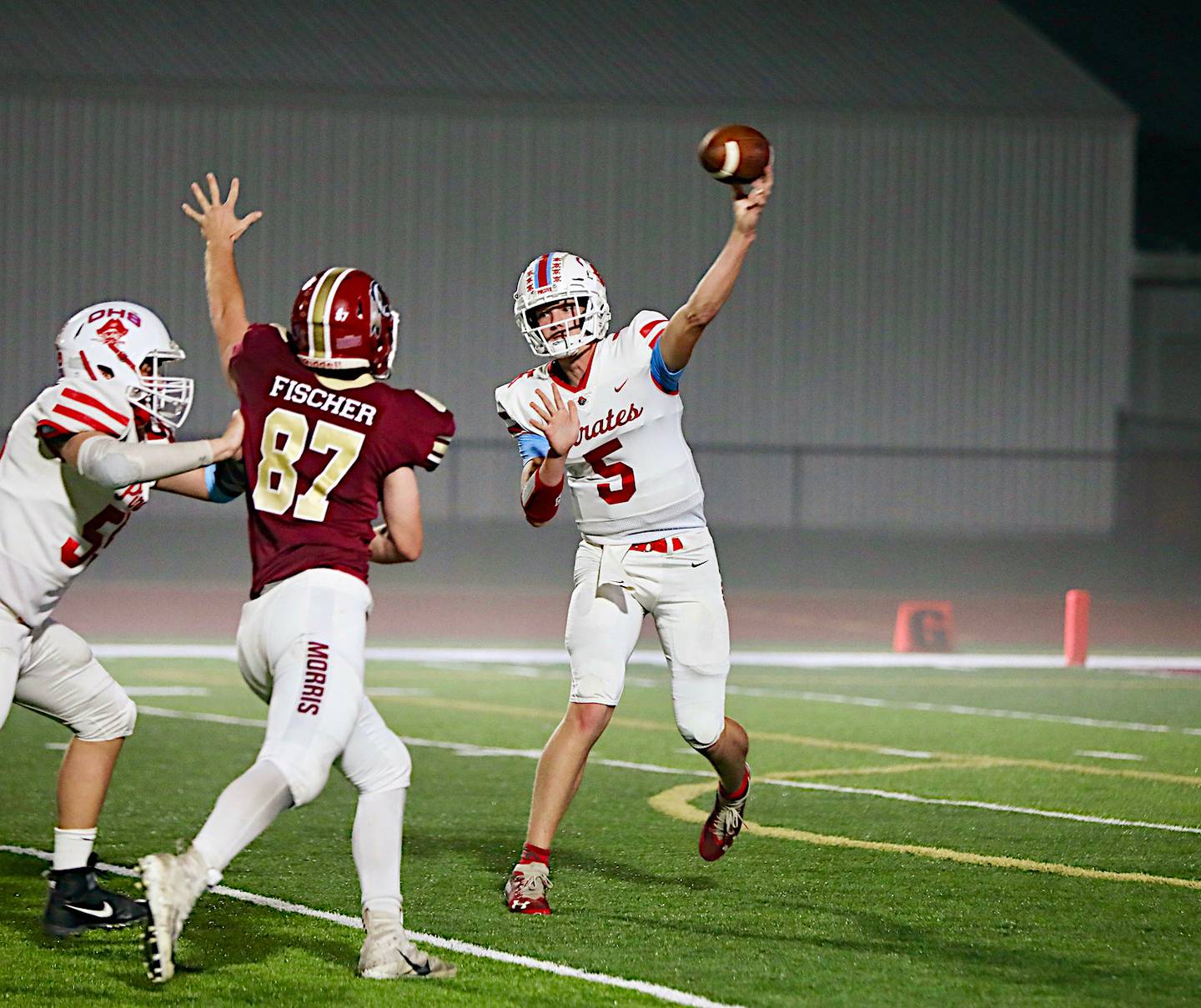 Ottawa's Braiden Miller throws a pass Friday night in a 49-0 loss to Morris as Morris' Ryan Fischer applies pressure. Miller was 11 of 21 for 120 yards.