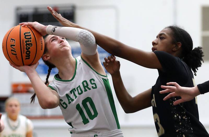 Crystal Lake South's Mallory Glover is fouled by Grayslake North's Anisah Lawrence during a Northern Illinois Holiday Classic semifinal girl basketball game on Tuesday, Dec. 16, 2025, at McHenry High School.