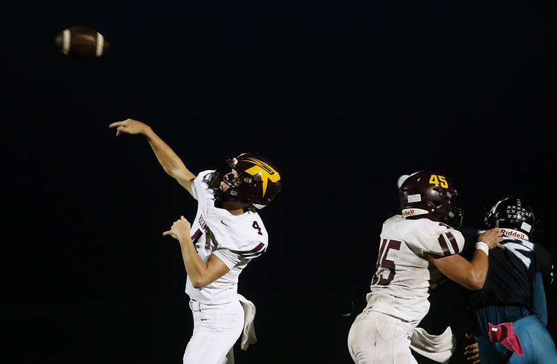 Richmond-Burton's Ray Hannemann throws a pass as Richmond-Burton's Riley Shea blocks Woodstock North's Jackson Burris during a Kishwaukee River Conference football game on Friday, Oct. 10, 2025, at Woodstock North High School.