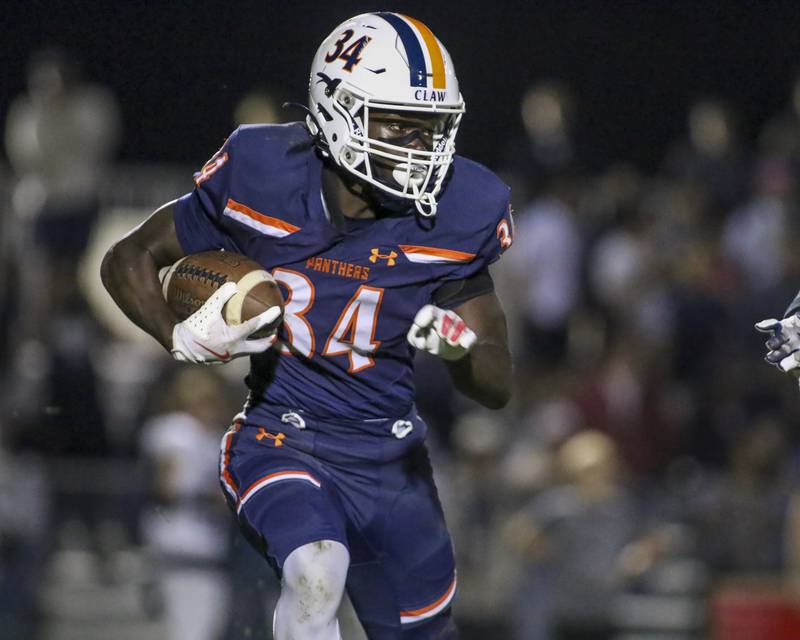 Oswego's Ammar Banire (34) runs with the ball during football game between Oswego East at Oswego Friday, Oct 17, 2025 in Oswego.