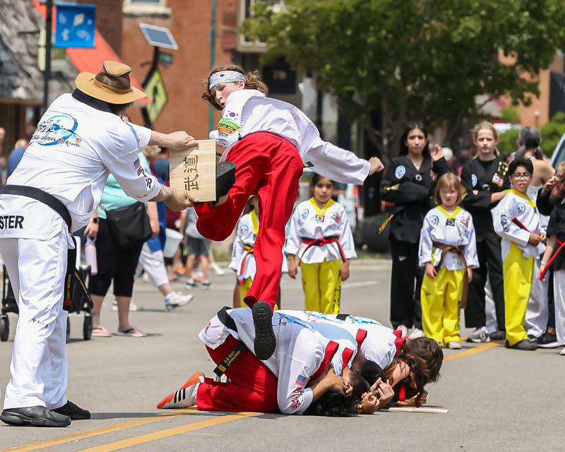 A martial arts student breaks a board in the annual PrairieFest parade in downtown Oswego. June 18, 2023.