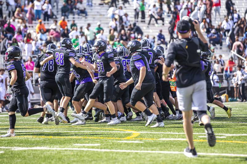 Downers Grove North rushes the field after winning their football game at Morgan Park Saturday, Aug 30, 2025  in Chicago.