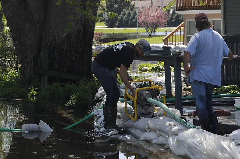 Volunteers work to protect a home in Holiday Hills  as flooding continues on the Fox River on Wednesday, April 22, 2026.
