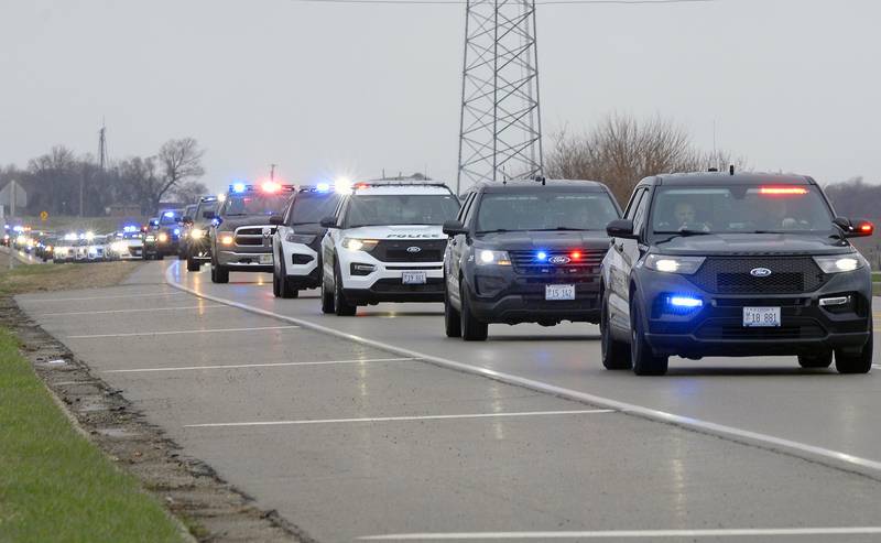 An estimated mile-long funeral procession for Ottawa Police Officer Brian Sember with police and emergency vehicles passes through Grand Ridge on Route 23 as it makes its way from Ottawa to Streator, Friday, April 8, 2022.