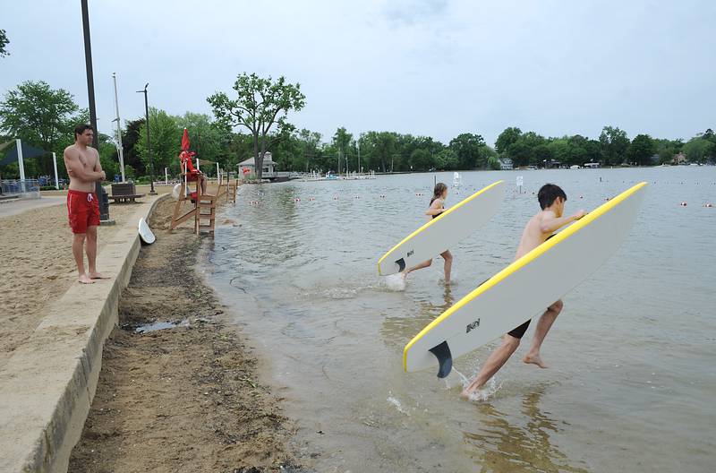 Lifeguard instructor Tommy Landt watches a lifeguards train on paddle boards Wednesday, June 1, 2022, during a training session at Crystal Lake's Main Beach.