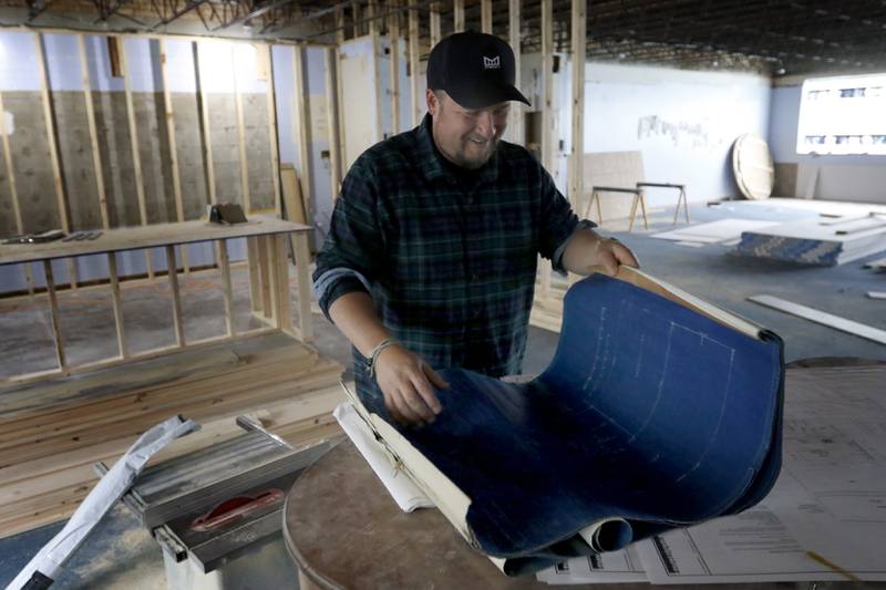 Brent Hollenberg looks a set of blueprints from the original Ridgefield schoolhouse at 8617 Ridgefield Road, near Crystal Lake on Wednesday, May 21, 2025. Hollenberg plans to turn the schoolhouse into a six-unit Airbnb. The building was last the home of the McHenry County Jewish Congregation.