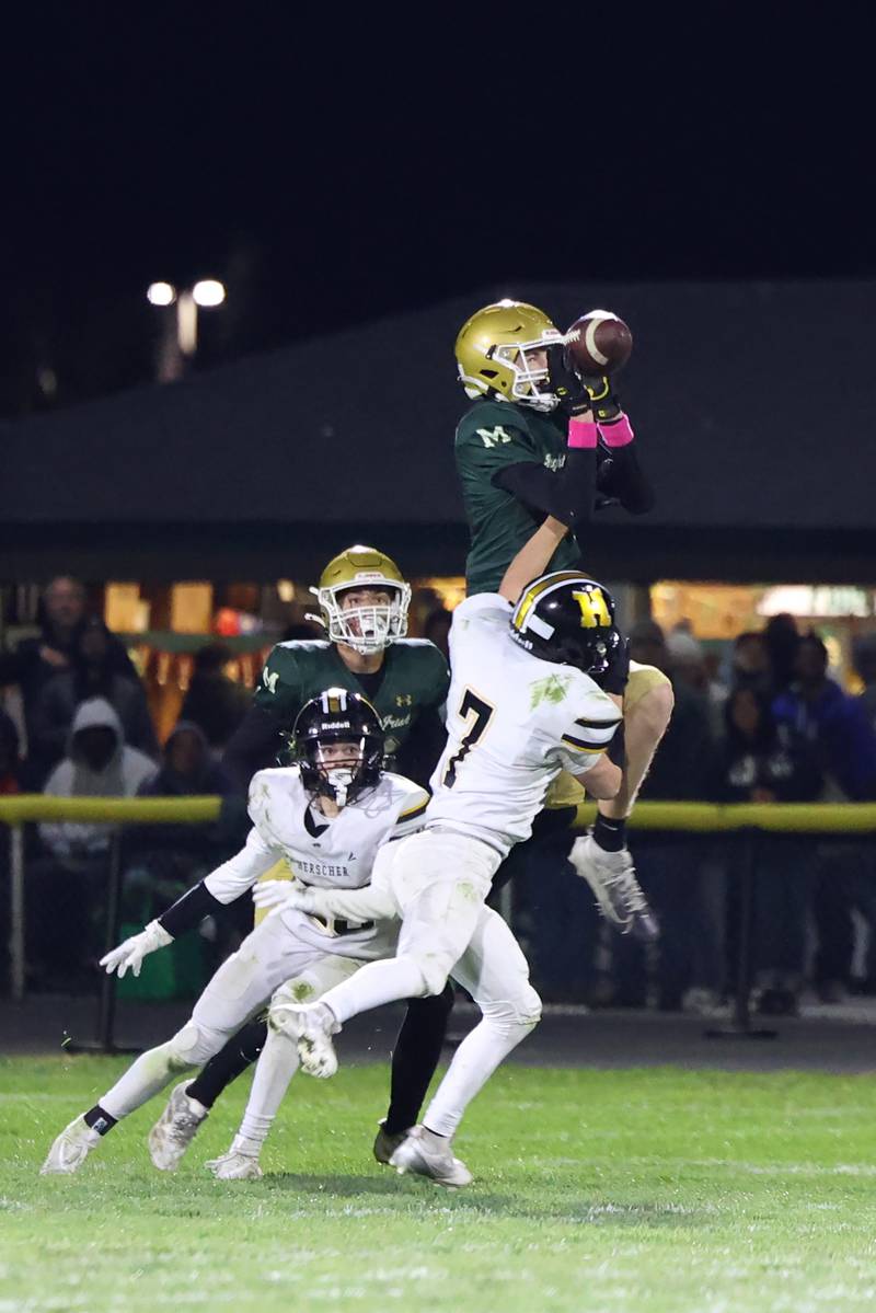 Bishop McNamara's Richie Darr catches a pass under pressure from Herscher's Gaige Brown during Bishop McNamara's 38-14 victory in the IHSA Class 3A first round playoff game on Friday, Oct. 31, 2025.