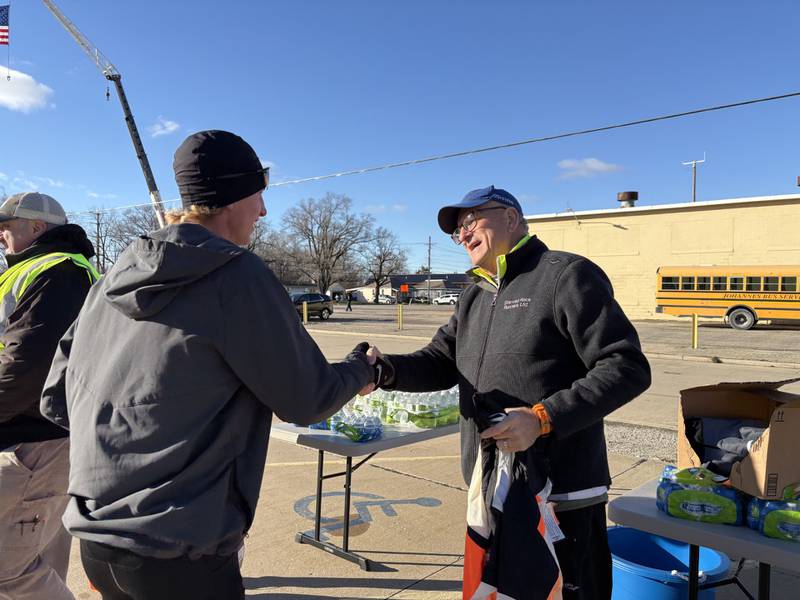Race director Mitchell Hobbs shakes hands with Blake Oleson after Oleson took home first place at Thursday’s Oglesby Turkey Trot.