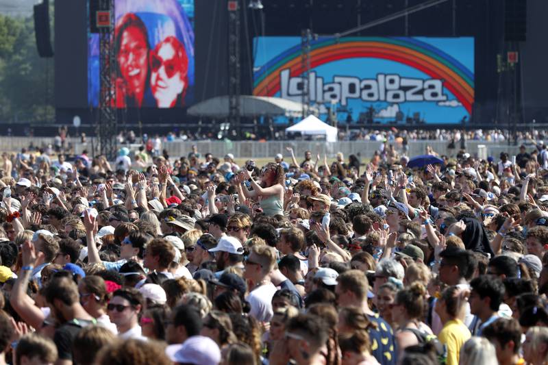 FILE - In this July 29, 2021 file photo, fans gather and cheer on day one of the Lollapalooza music festival at Grant Park in Chicago. Chicago health officials on Thursday, Aug. 12, 2021, reported 203 cases of COVID-19 connected to Lollapalooza, casting it as a number that was anticipated and not yet linked to any hospitalizations or deaths.  (AP Photo/Shafkat Anowar File)