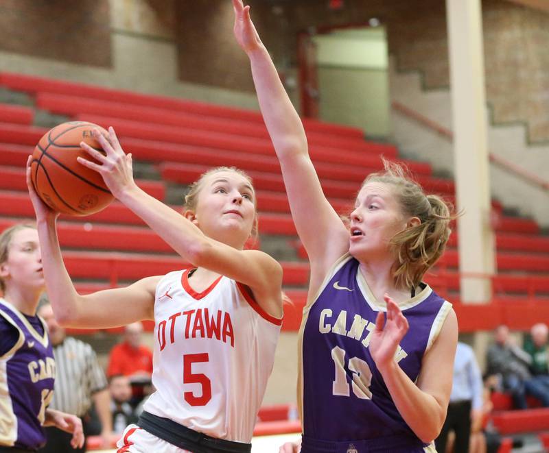Ottawa's Grace Carroll (left) runs into the lane to score a basket over Canton's Karlee Zumstein (right) during the Lady Pirate Holiday Tournament on Wednesday, Dec. 21, 2022 in Ottawa.