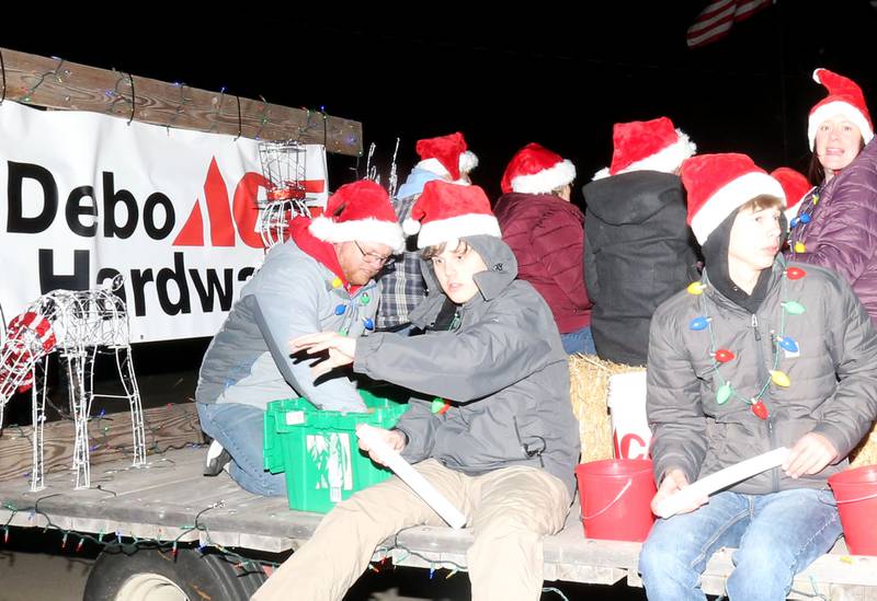 Debo Ace Hardware employees throw candy during the annual Christmas Parade on Saturday, Dec. 7, 2024 on Peoria Street in Peru.