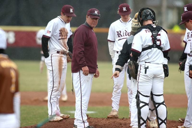 Prairie Ridge’s Head Coach Glen Pecoraro and the Wolves assess field conditions just before the game against Jacobs was suspended  in varsity baseball on Wednesday, April 9, 2025, at Prairie Ridge High School in Crystal Lake.
