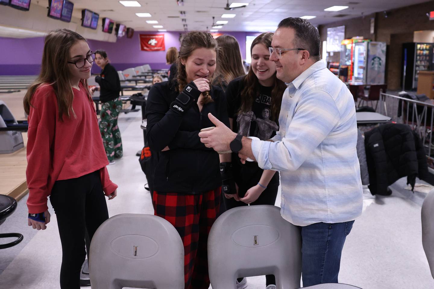 Lincoln-Way West’s bowling coach Scott Ullian has a light hearted moment with his team during practice at Laraway Lanes in New Lenox.