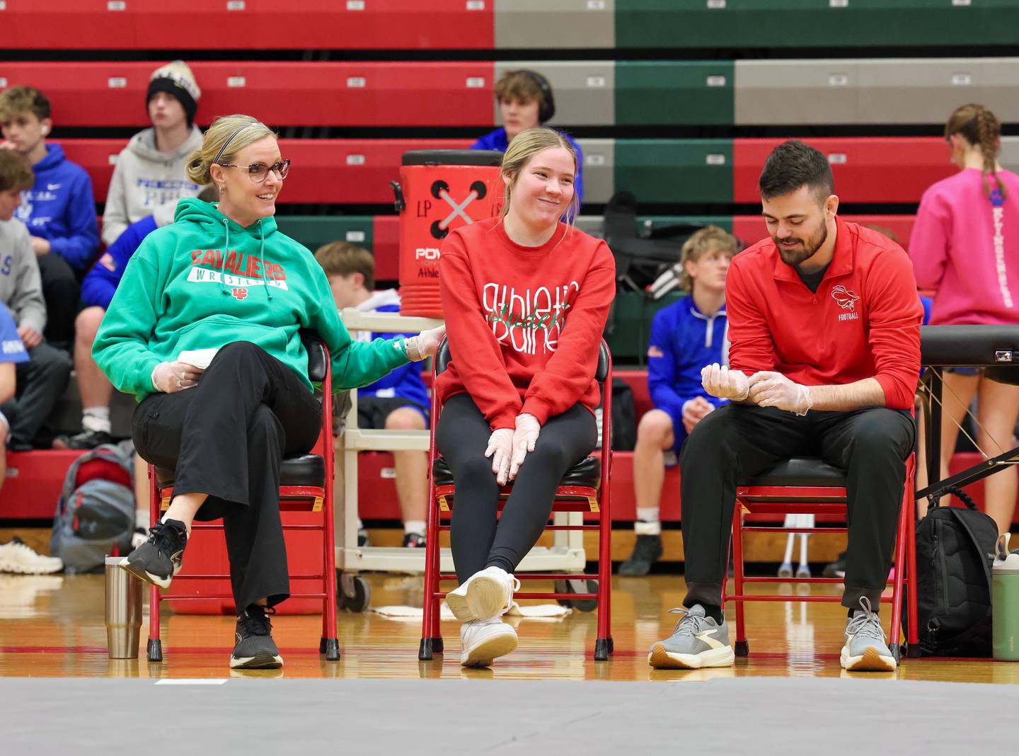 La Salle-Peru athletic trainer Gina Martin (left) talks with student trainer Julia Baker and athletic trainer Trevor Samolinski.