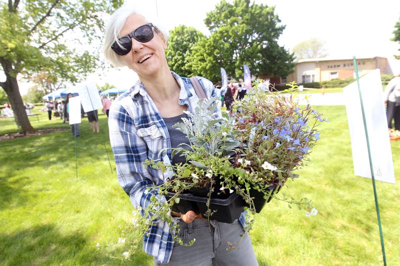 Rita Meskauskaite, of Gurnee, is all smiles as she holds some of flowers she was getting Saturday, May 20, 2023, during the Lake County Extension Master Gardener Spring Plant Sale at the University of Illinois Extension in Grayslake.