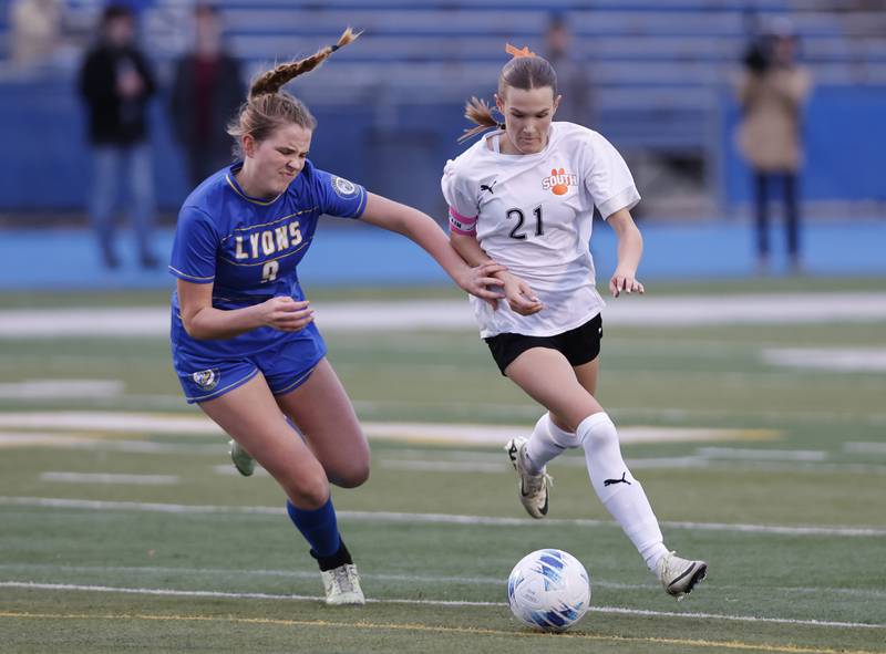 Wheaton Warrenville South's Ashlyn Adams (21) goes for the ball against against Lyons Township's Claire Mortonson (9) during the girl's varsity soccer match between Lyons Township and Wheaton Warrenville South high schools on Thursday, March 27, 2025 in Western Springs.