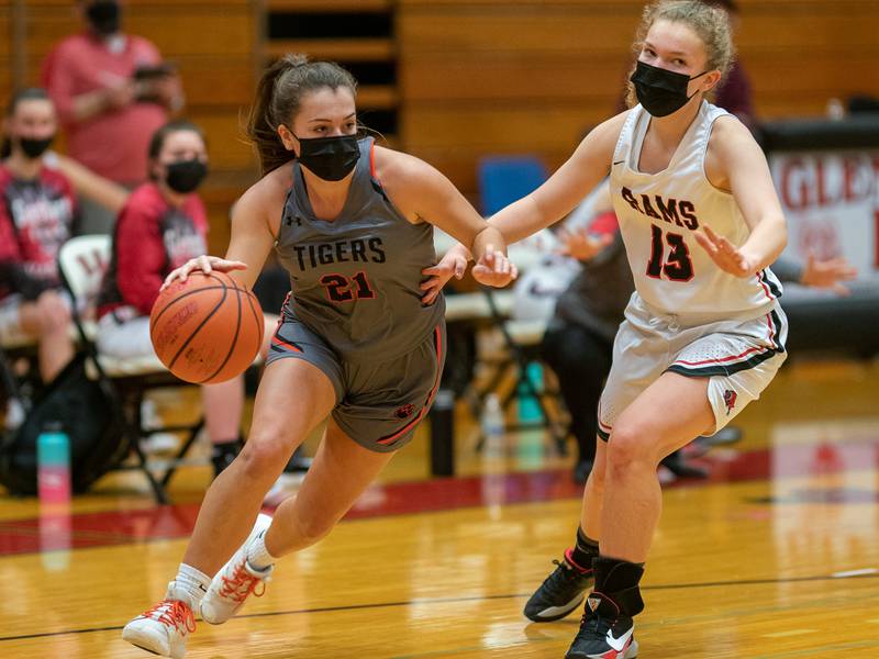 Wheaton Warrenville South's Emma Showman (21) drives the baseline against Glenbard East's Catey Carney (13) during a game in Lombard Feb. 18