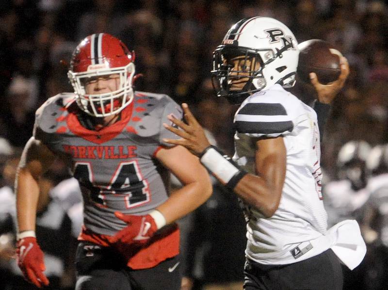 Plainfield North quarterback Demir Ashiru makes a pass ahead of the rush by Yorkville defender Jake Davies (44) during the homecoming varsity football game at Yorkville High School on Friday, Sept. 23, 2022.