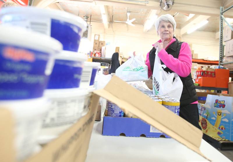 Celeste Nagel gathers bags full of food during the annual Thanksgiving distribution on Wednesday, Nov. 20, 2024 at the Hall Township Food Pantry in Spring Valley.