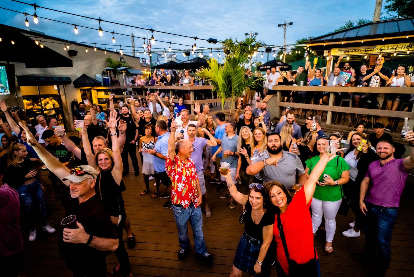 Patrons enjoy the summer vibe near the patio stage at 3D Sideouts Sports Tavern on Roberts Road in Island Lake.