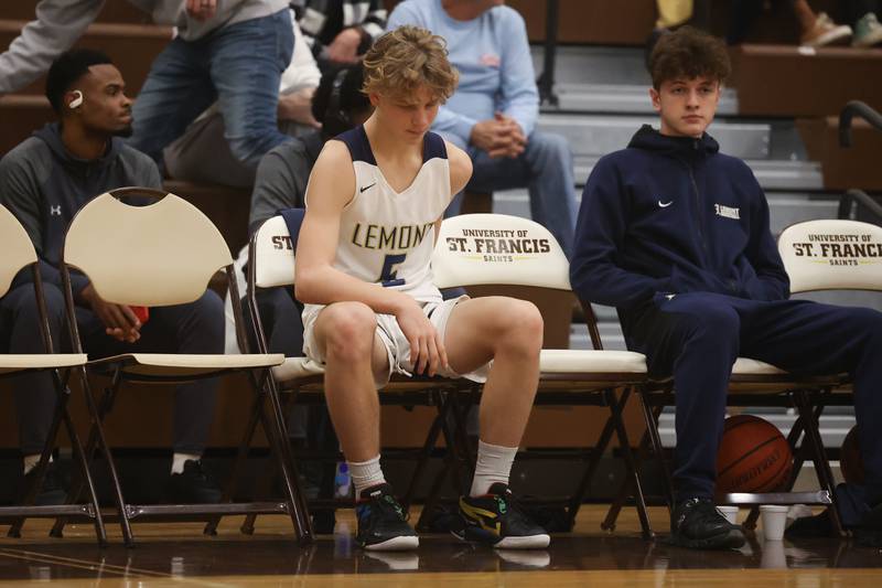 Lemont’s Rokas Castillo sits on the final minutes against Romeoville after taking a frightful fall in the WJOL Thanksgiving Classic Championship in Joliet on Saturday.