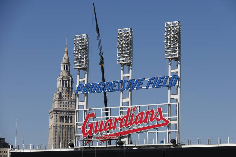 FILE - Workers finish installing the Cleveland Guardians sign above the scoreboard at Progressive Field, March 17, 2022, in Cleveland. (AP Photo/Ron Schwane, file)