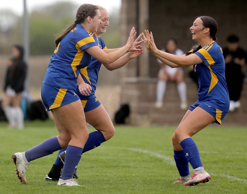 Johnsburg's Elaina Moss, (left) Kayla Hiller (center) and  Devynn Michel (right) celebrate a goal during a Kishwaukee River Conference soccer match against Harvard on Wednesday, April 27, 2026, at Johnsburg High School.