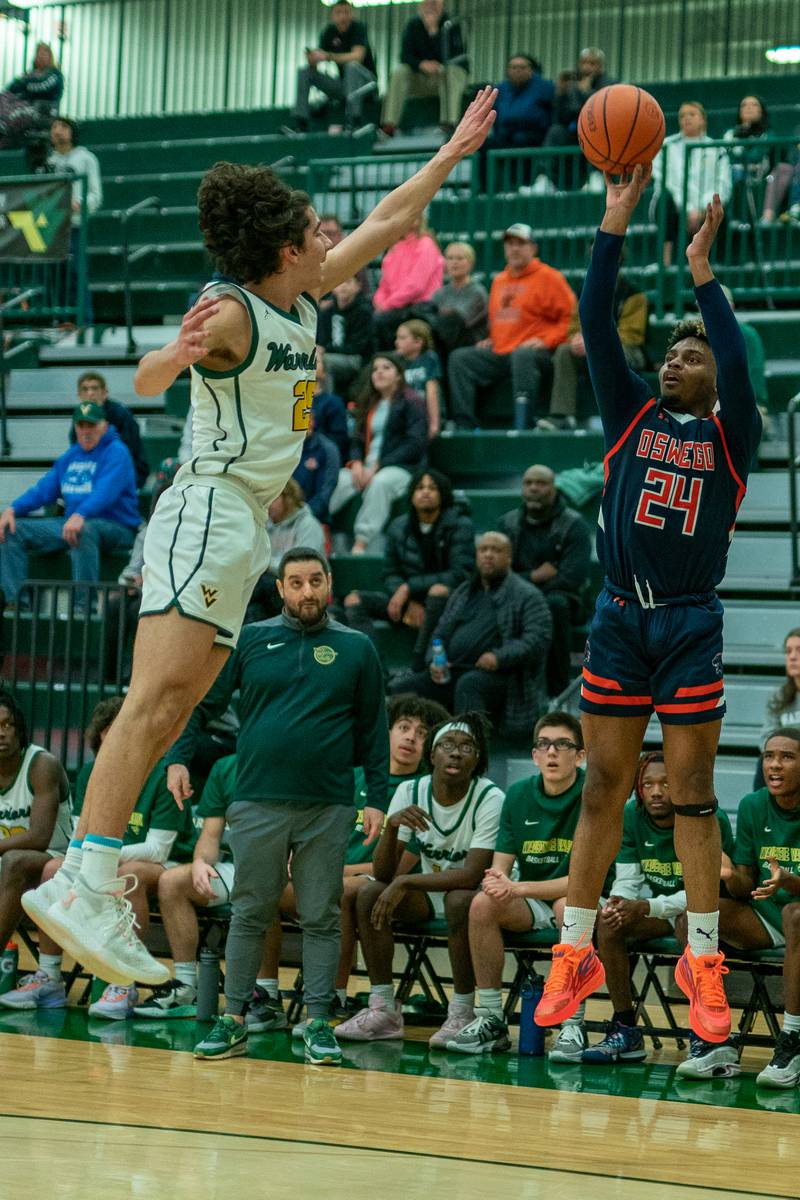 Oswego’s Jeremiah Akin (24) shoots a three-pointer against Waubonsie Valley's Jackson Langendorf (25) during a Waubonsie Valley 4A regional semifinal basketball game at Waubonsie Valley High School in St.Charles on Wednesday, Feb 22, 2023.