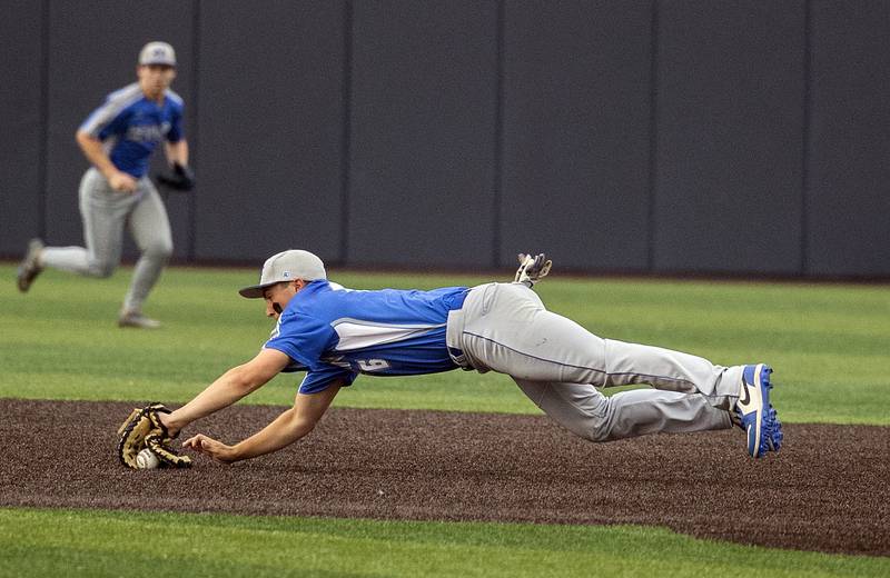 Newman’s Evan Bushman makes a diving stop at first against Teutopolis Friday, June 6, 2025, during the Class 2A state semifinal at Illinois Field in Champaign.