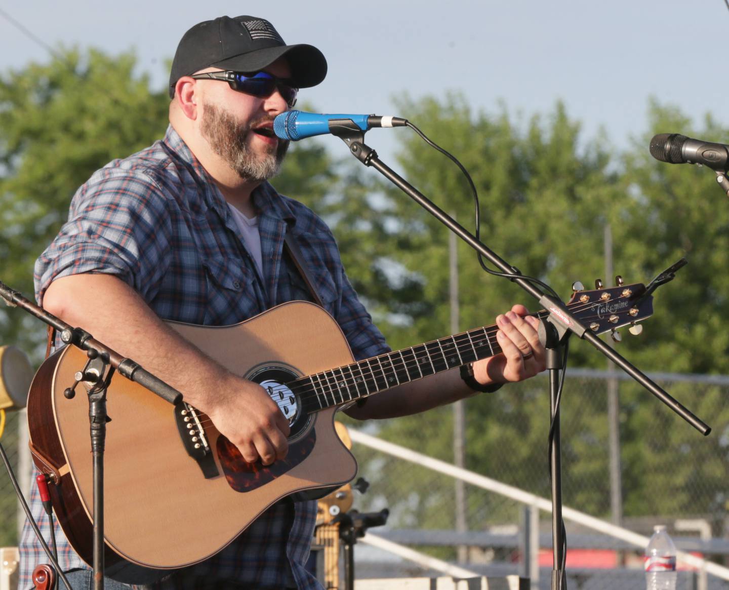 Cody Calkins sings a song as the opening act during the Marshall-Putnam Fair on Thursday, July 14, 2022 in Henry.