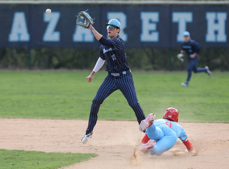 Benet's Lucas Lawler (9) slides into second as Nazareth's David Cox (27) catches the throw during the varsity baseball game between Benet Academy and Nazareth Academy in La Grange Park on Monday, April 24, 2023.