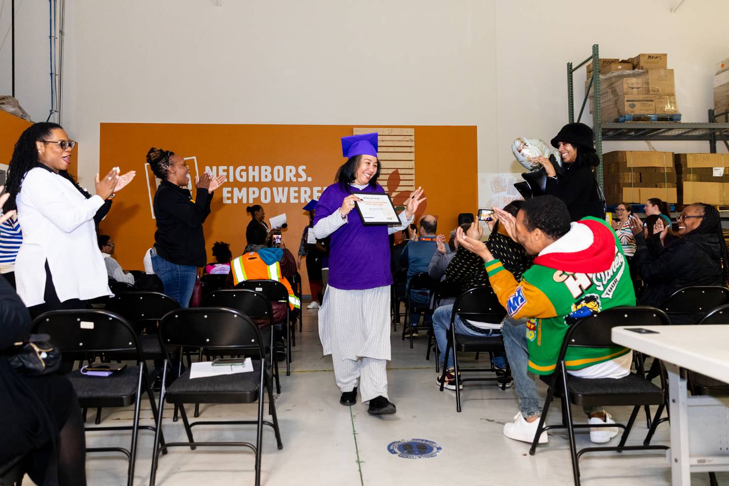 S.E.E.D. graduate Bernita Perkins displays her certificate to the crowd following the ceremony at the Northern Illinois Food Bank South Suburban Center in Joliet on March 14, 2024.