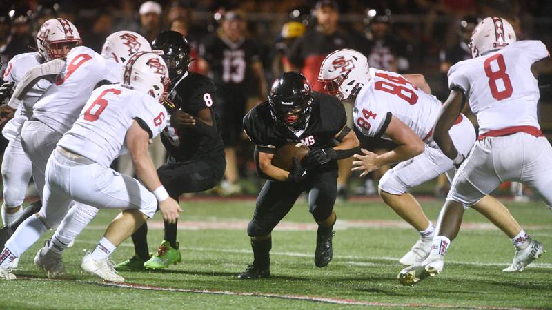 Glenbard East's Matthew Larson, center, finds a hole in the South Elgin defense during Friday’s football game in Lombard.