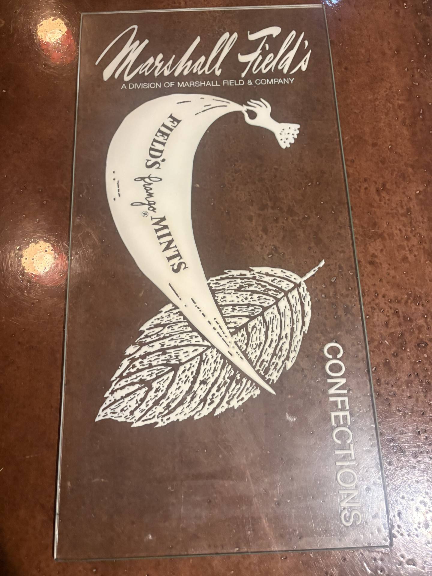 A glass Frango sign that hung on the 7th floor outside a display candy kitchen in the original Marshall Field's Department Store on State Street in Chicago. The display kitchen showed shoppers how Frango mints were originally made.