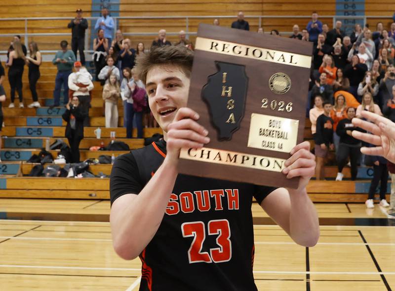Wheaton Warrenville South's David Showman (23) holds the championship plaque after winning the IHSA boys class 4A Willowbrook regional final between Wheaton Warrenville South and Batavia on Friday, Feb. 27, 2026 in Villa Park, IL.