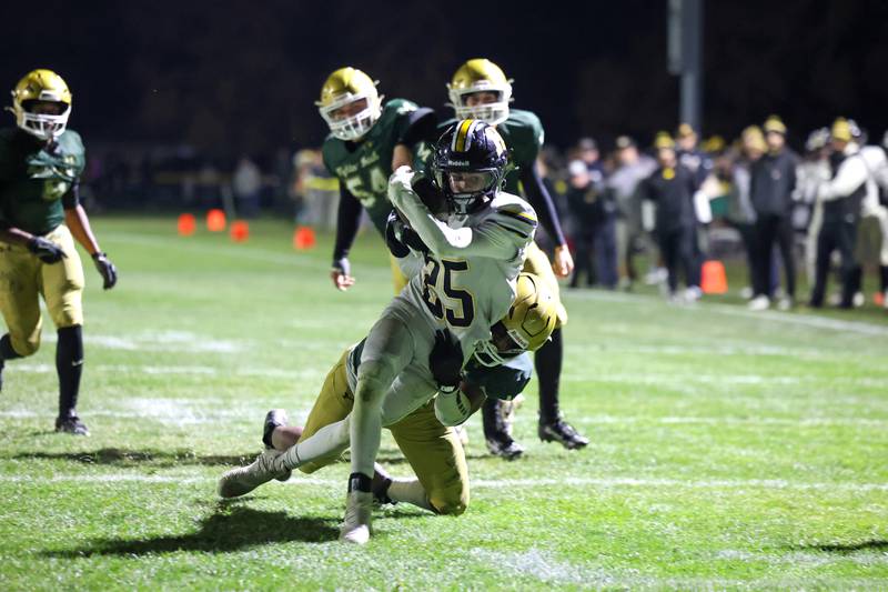 Herscher's Mason Roberts is brought down short of the goal line by Bishop McNamara's Jordan Callaway during Bishop McNamara's 38-14 victory in the IHSA Class 3A first round playoff game on Friday, Oct. 31, 2025.