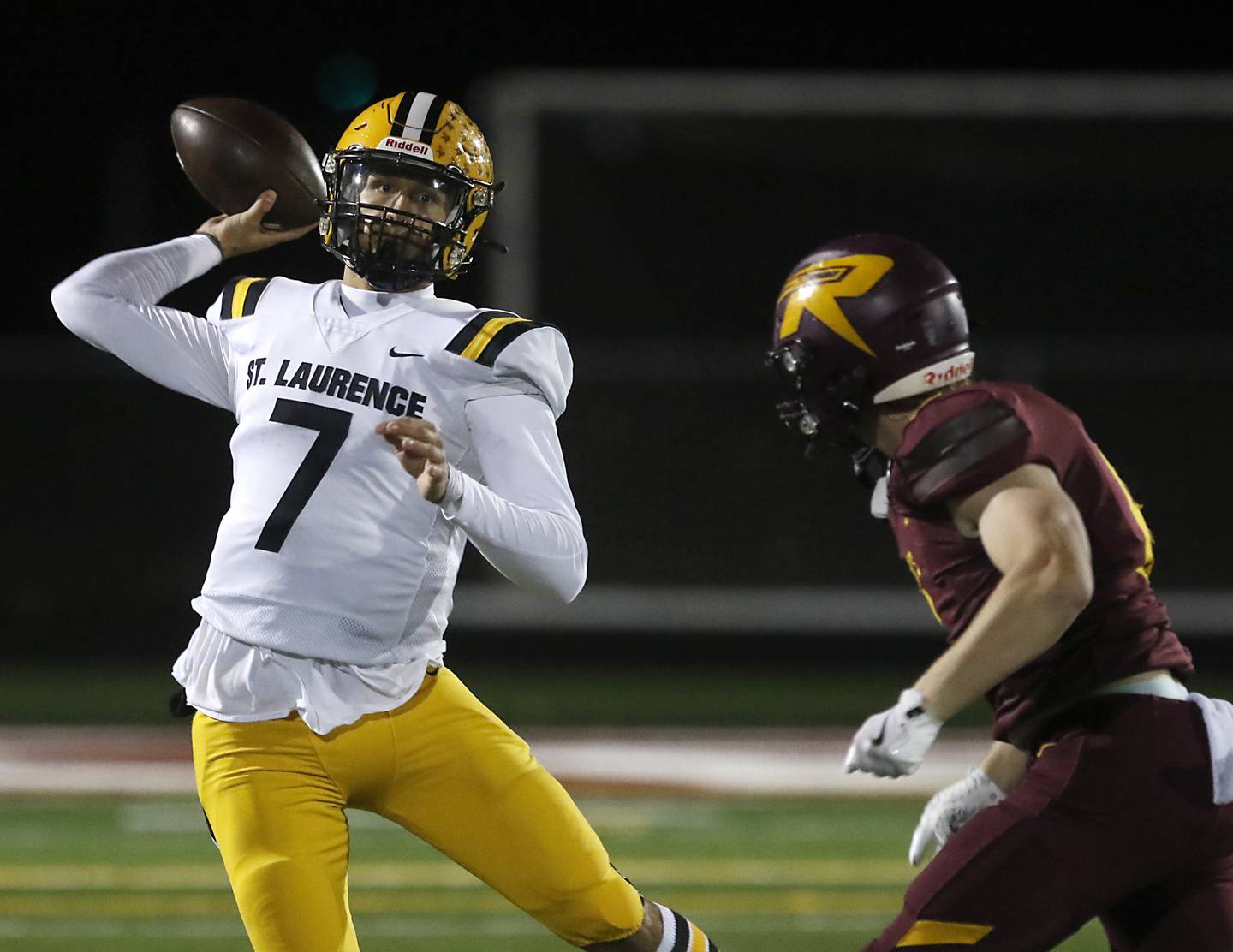 St. Laurence's Chase Kwiatkowski throws a pass as Richmond-Burton's Ryan Wisniewski classes in during an IHSA Class 4A first-round football game on Friday, Nov. 1, 2024, at Richmond-Burton High School in Richmond.