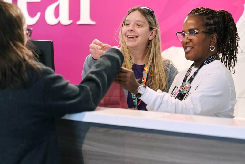 Jessica Beatrice, (left) of DeKalb, is waited on by Excelleaf budtender Jamie Cardenaz and one of the owners Maria Davis (right) Friday, Nov. 24, 2023, during the soft opening of the dispensary in DeKalb. The business is DeKalb County’s first recreational marijuana dispensary.